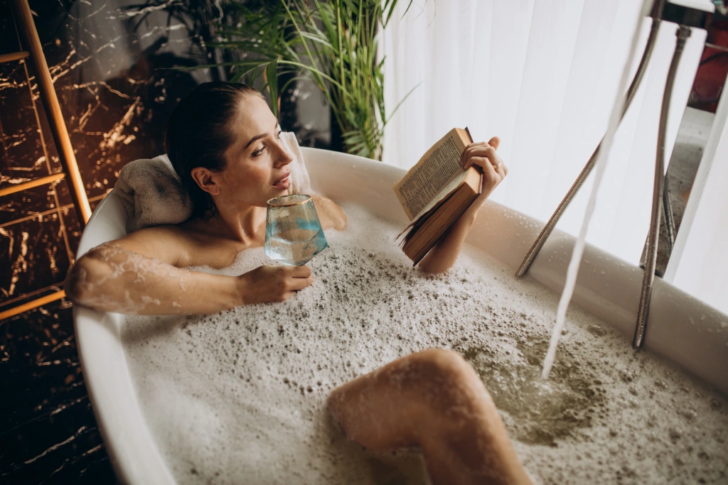 woman-relaxing-bath-with-bubbles-drinking-wine.webp