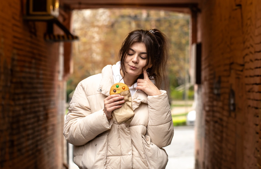 attractive-young-woman-with-gingerbread-blurred-background-copy-space.webp